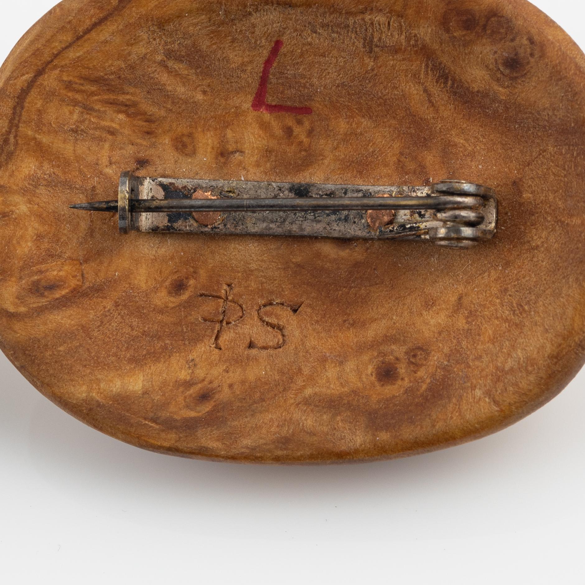 A brooch attributed to Per Sunna and a pendant, both in birch and engraved reindeer horn,