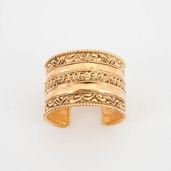 CHANEL, a gold colored metal cuff braclet.