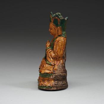 A yellow and green glazed pottery figure of a seated Buddha, Ming dynasty, 17th century.