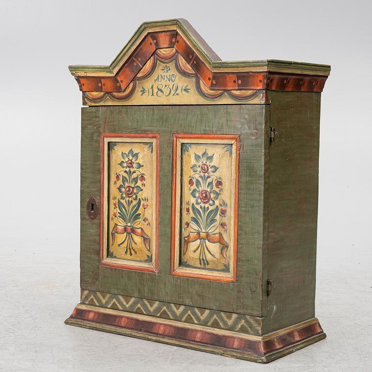 A hanging cabinet, dated 1832.