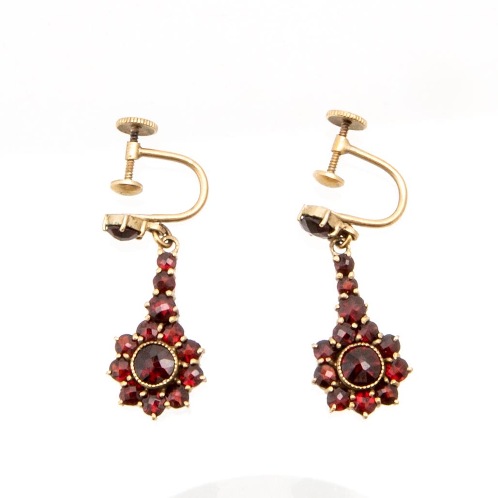 Necklace, earrings, and brooch with faceted garnets.