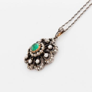 A silver pendant set with a cabochon-cut emerald and rose-cut diamonds.