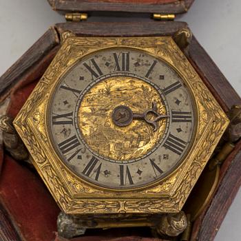 A gilded brass baroque travel clock from around 1700, with original case.