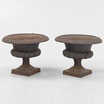 A pair of cast iron garden urns, 20th century.