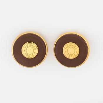 Hermès, a pair of gold tone metal and leather clip-on earrings.