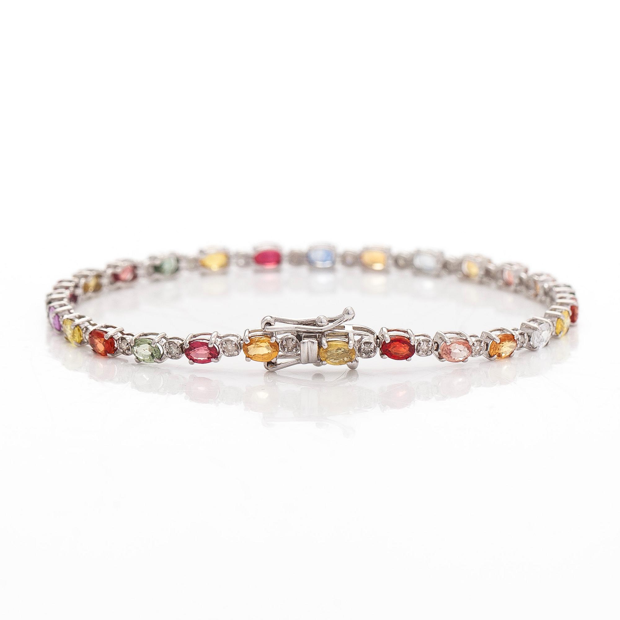 Rannekoru, 18K valkokultaa, monivärisillä safiireilla ja timanteilla.