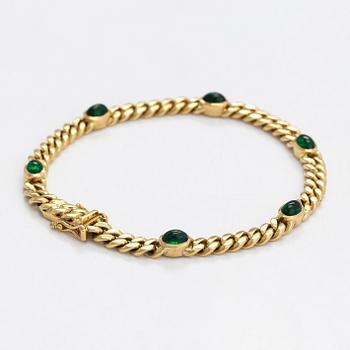An 18K gold curb link bracelet with cabochon-cut green garnets.