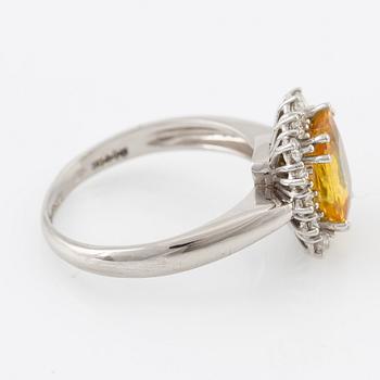 Ring in 18K gold with a yellow faceted sapphire and round brilliant-cut diamonds.