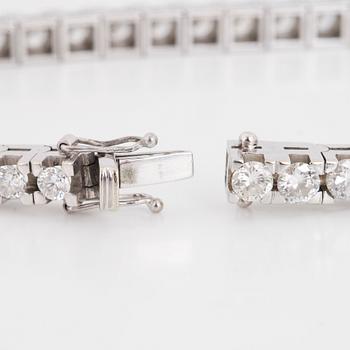 An 18K white gold tennisbraclet set with round brilliant-cut diamonds.