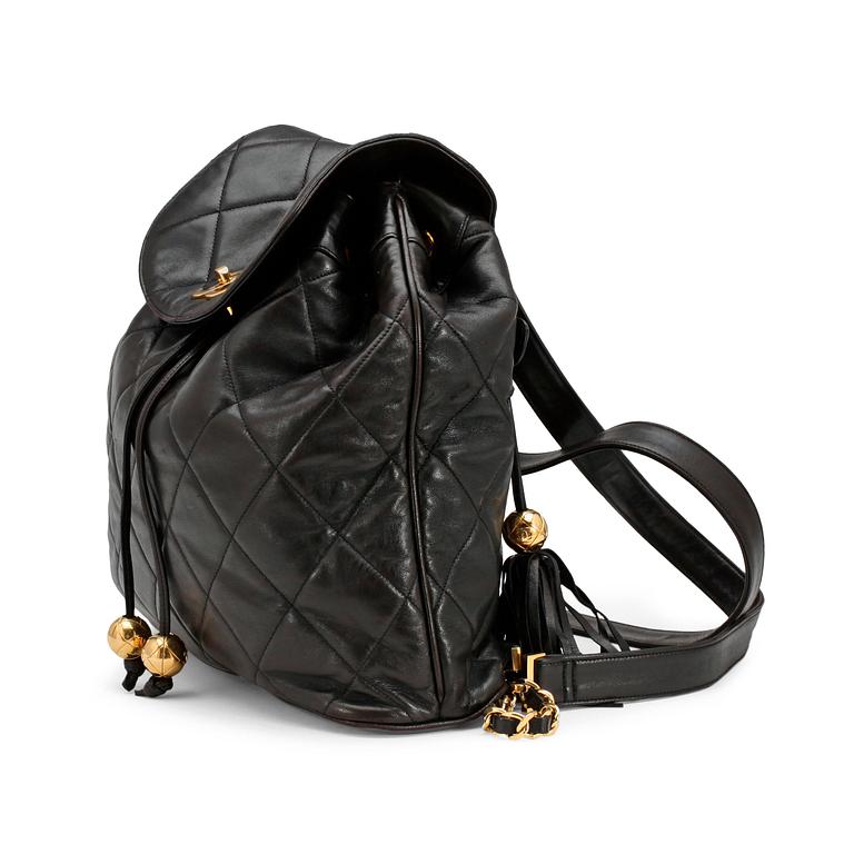 CHANEL, a black leather quilted backpack.
