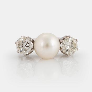 981. An 18K white gold ring set with a cultured pearl and two round brilliant-cut diamonds.