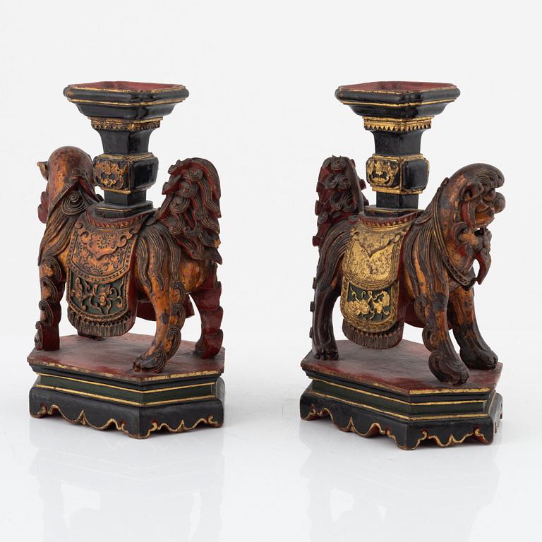 A pair of sculptured wooden candle holders, late Qing dynasty.