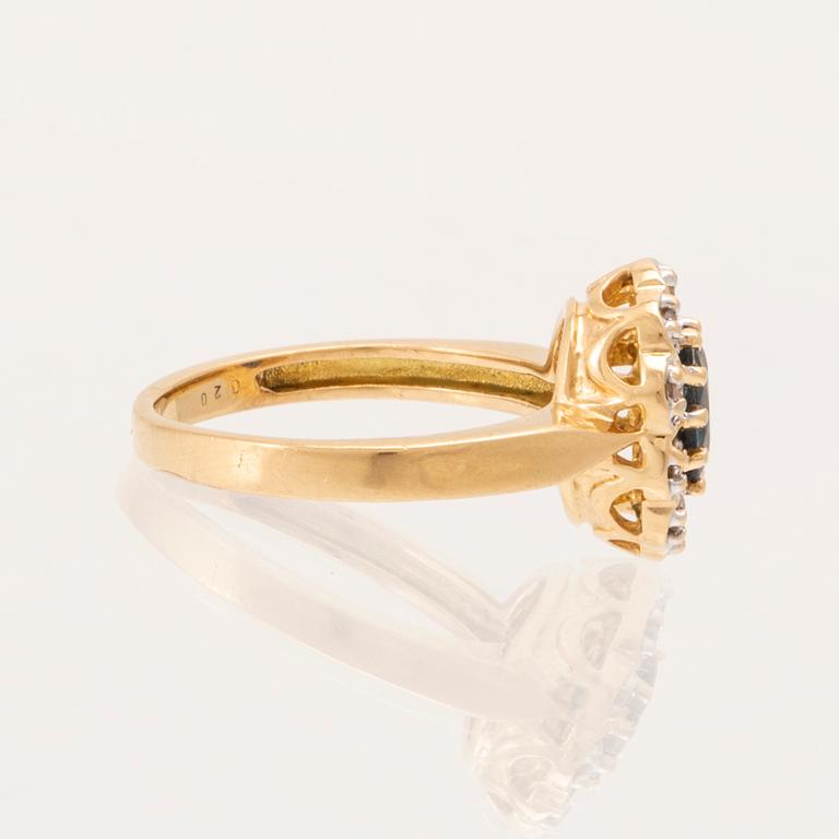 An 18K gold ring set with an oval faceted sapphire and round brilliant-cut diamonds.