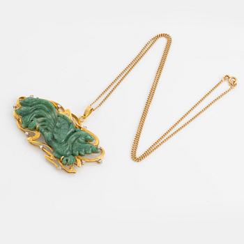 Pendant in gold with a carved green stone, adorned with brilliant-cut diamonds.