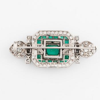 An 18K white gold Marchak art deco brooch set with step-cut emeralds.