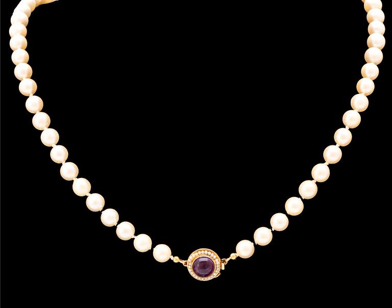 Ateljé Stigbert, a cultured pearl necklace with an 18K gold lock set with seed pearls and a cabochon cut amethyst, 1967.