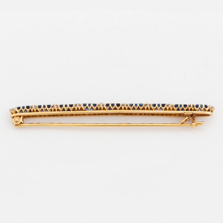 An 18K gold brooch set with step-cut sapphires and old-cut diamonds.