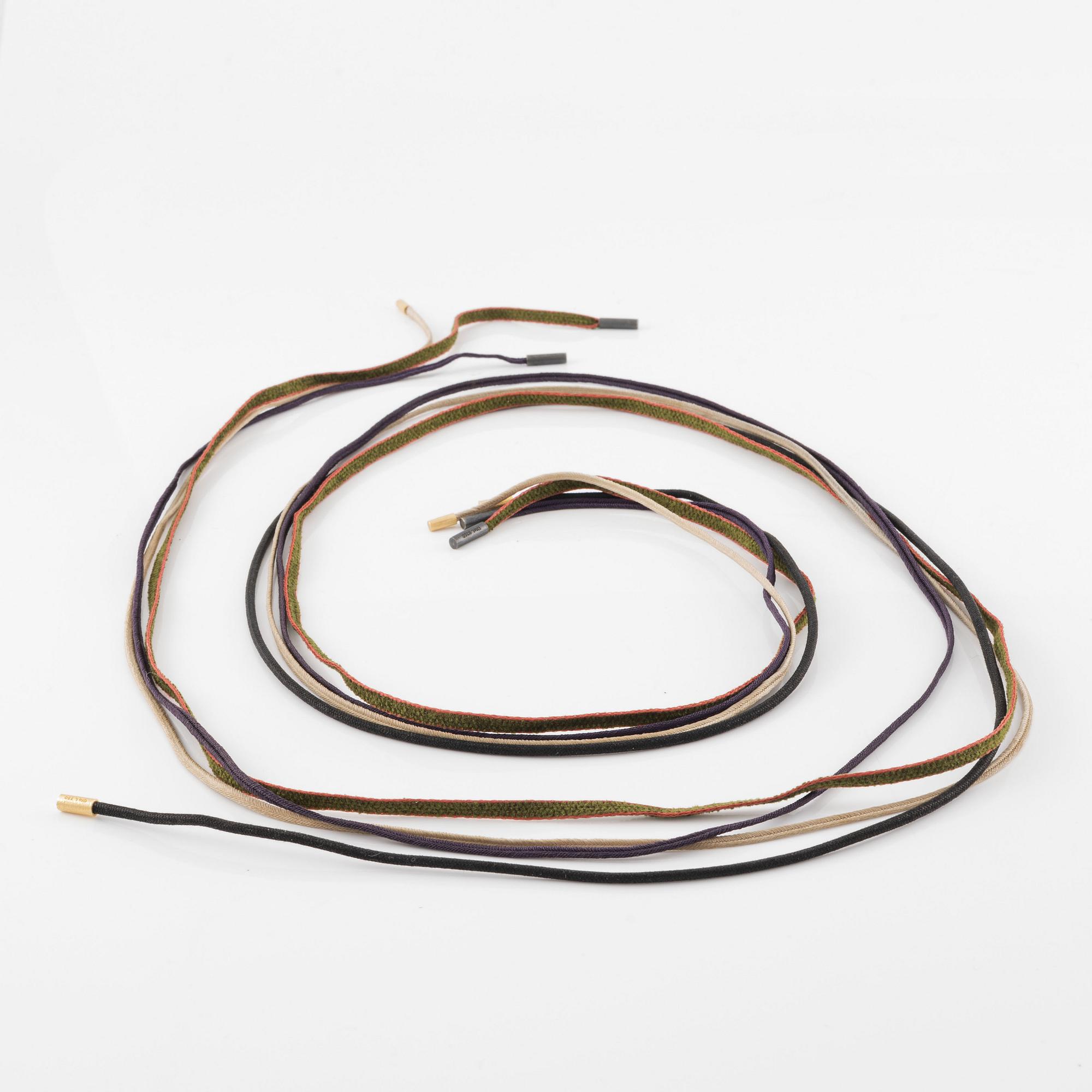 Ole Lynggaard fyra stycken halsband/remmar i textil samt guld och silver.