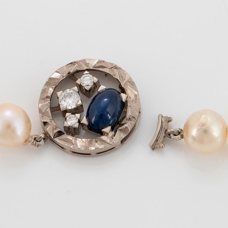 A Rey Urban cultured pearl necklace with an 18K white gold clasp set with a cabochon-cut sapphire.
