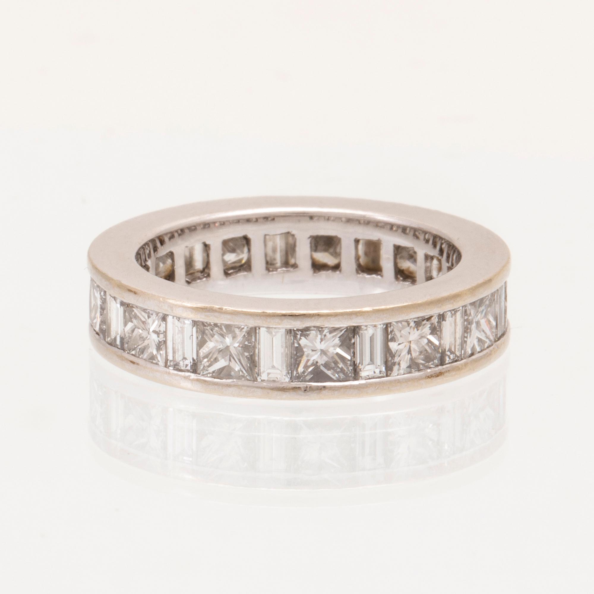 An 18K white gold eternity ring set with baguette and princess cut diamonds by Hartmann's Denmark.