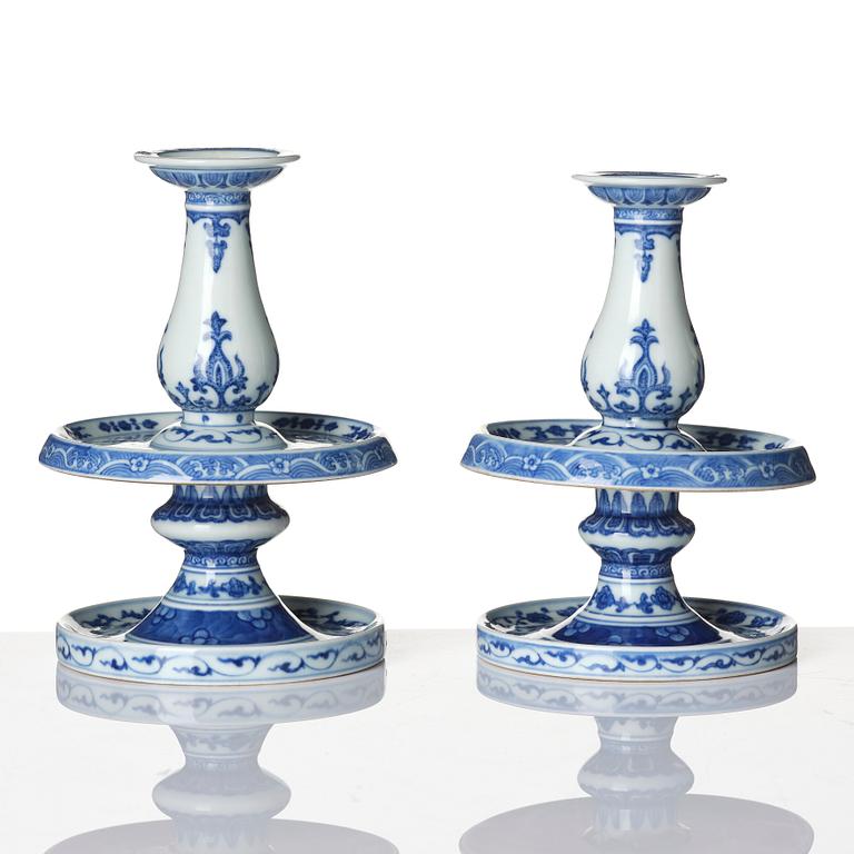 A pair of blue and white pricket candle sticks, with a poem, Qing dynasty with a Qianlong mark and of the period.