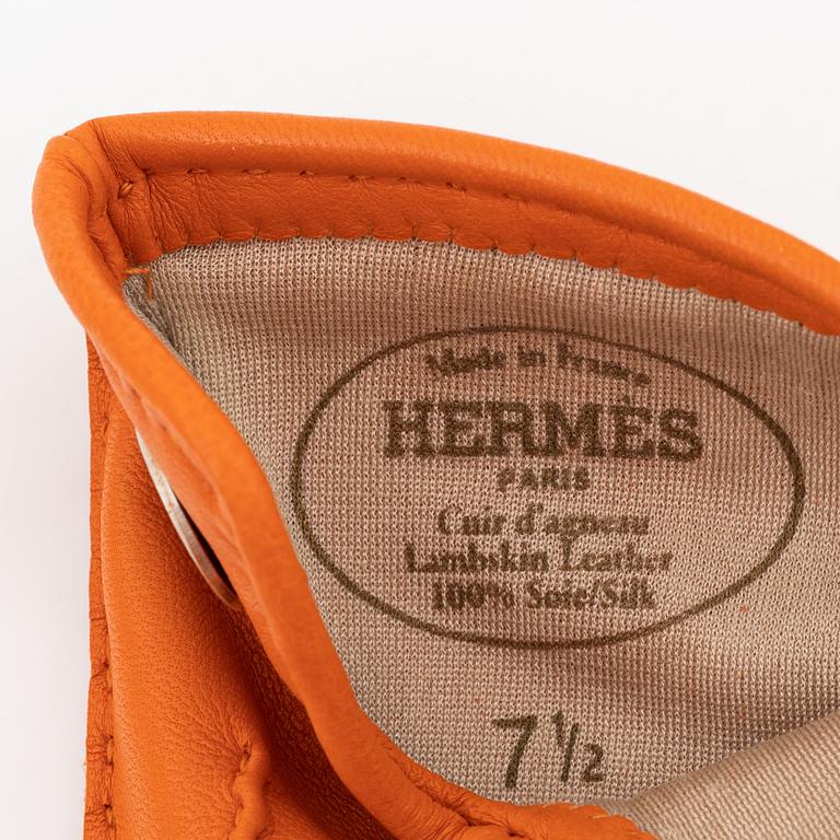Hermès, a pair of orange kidskin and lambskin gloves, french size 7 1/2.