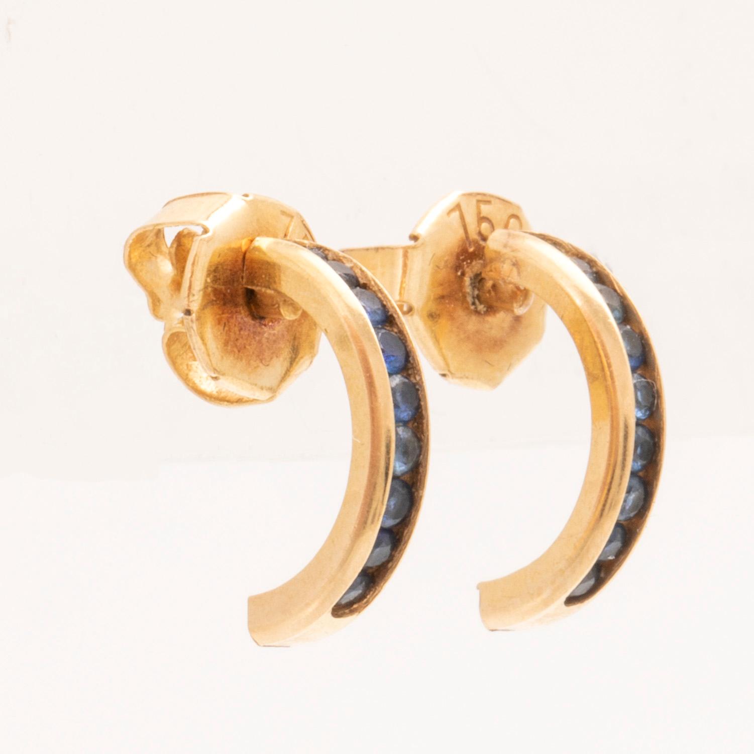 An 18K gold ring and a pair of earrings by H. Stern set with round brilliant cut diamonds and sapphires.