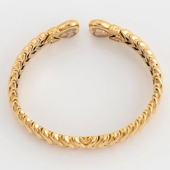 A Chopard "Happy Diamond" bangle in 18K gold.