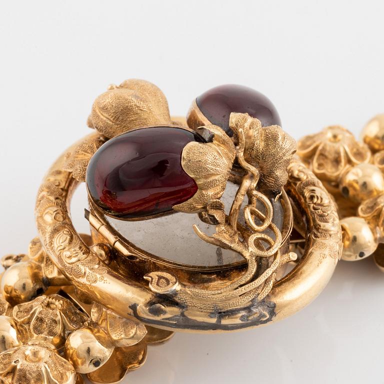 An 18K gold bracelet set with cabochon-cut garnets.