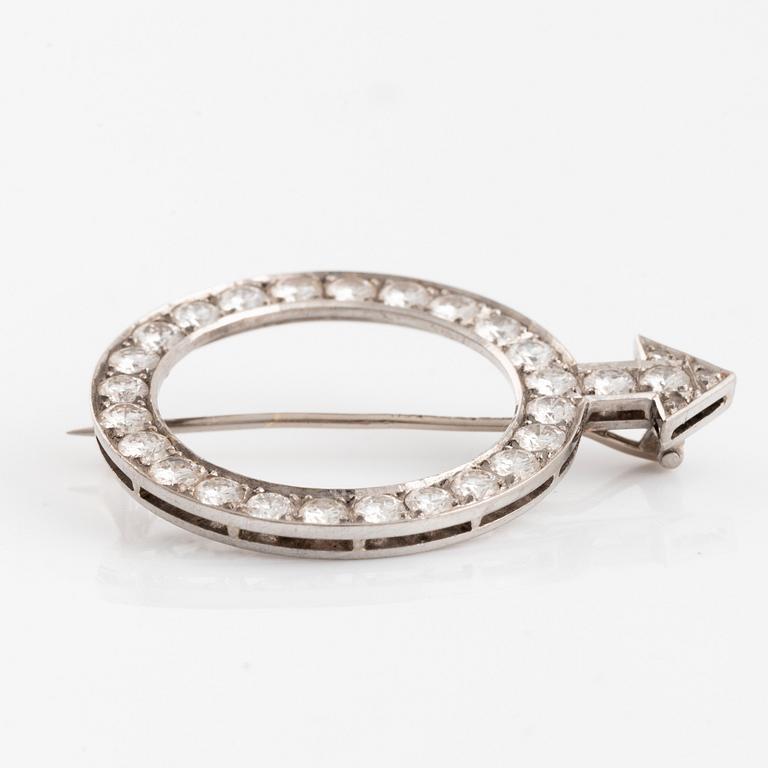 An 18K white gold brooch set with round brilliant-cut diamonds.