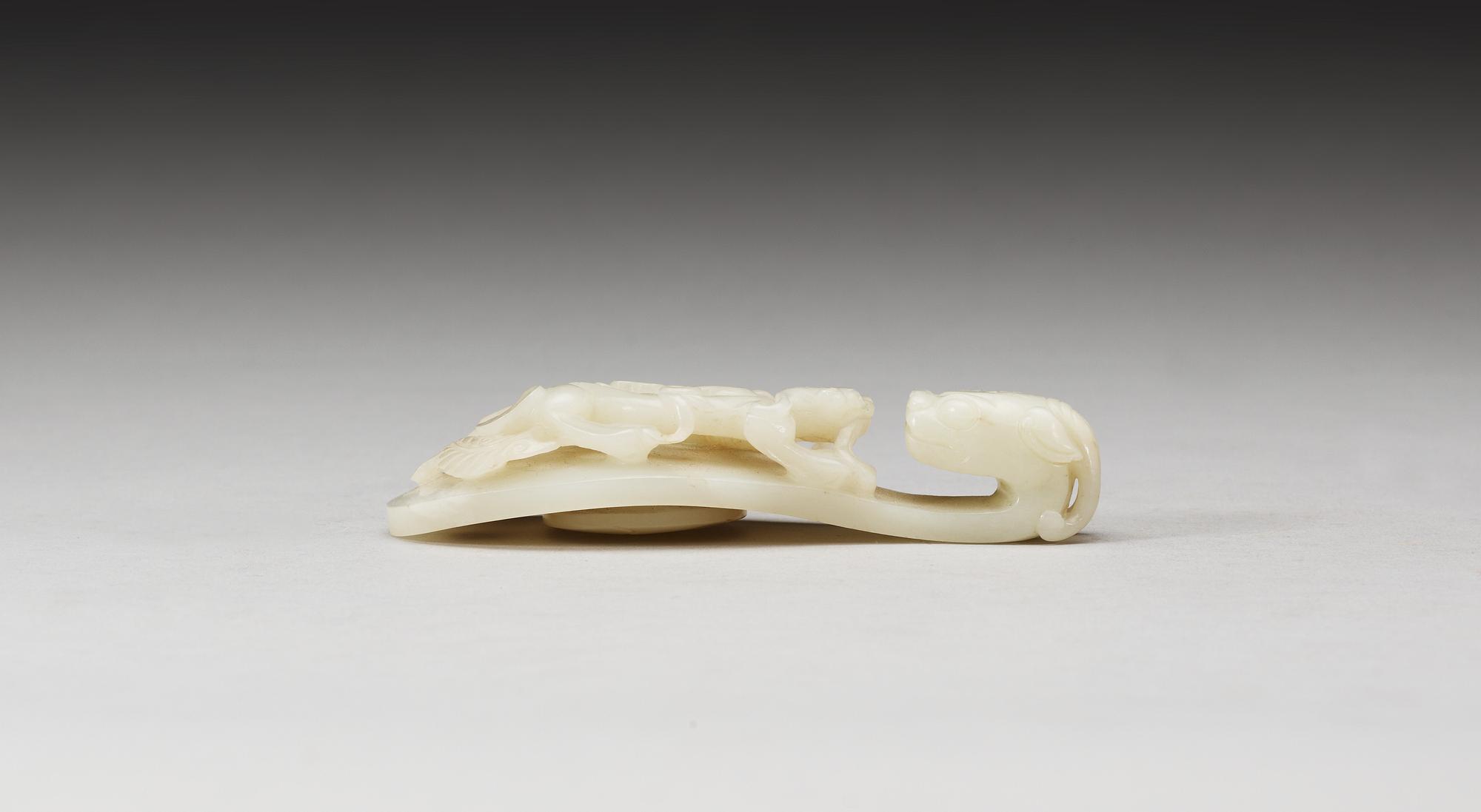 A pale green nephrite garment hook, Qing dynasty.