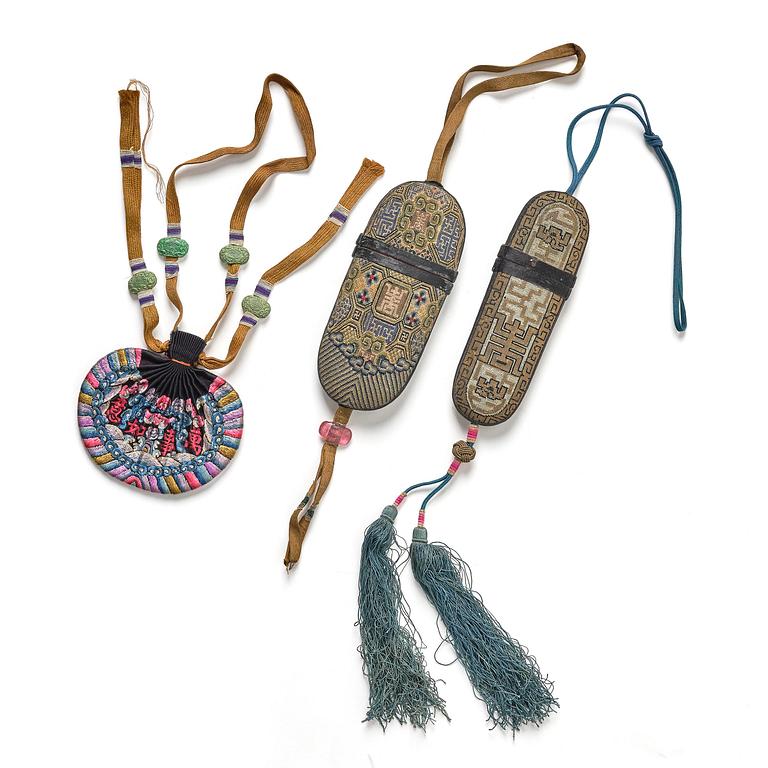 A set of three embroidered purses/ eye-glass cases, Qing dynasty, 19th century.