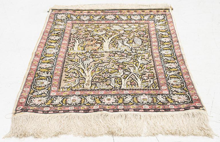 A figural silk Hereke rug, signed c. 92 x 61 cm.