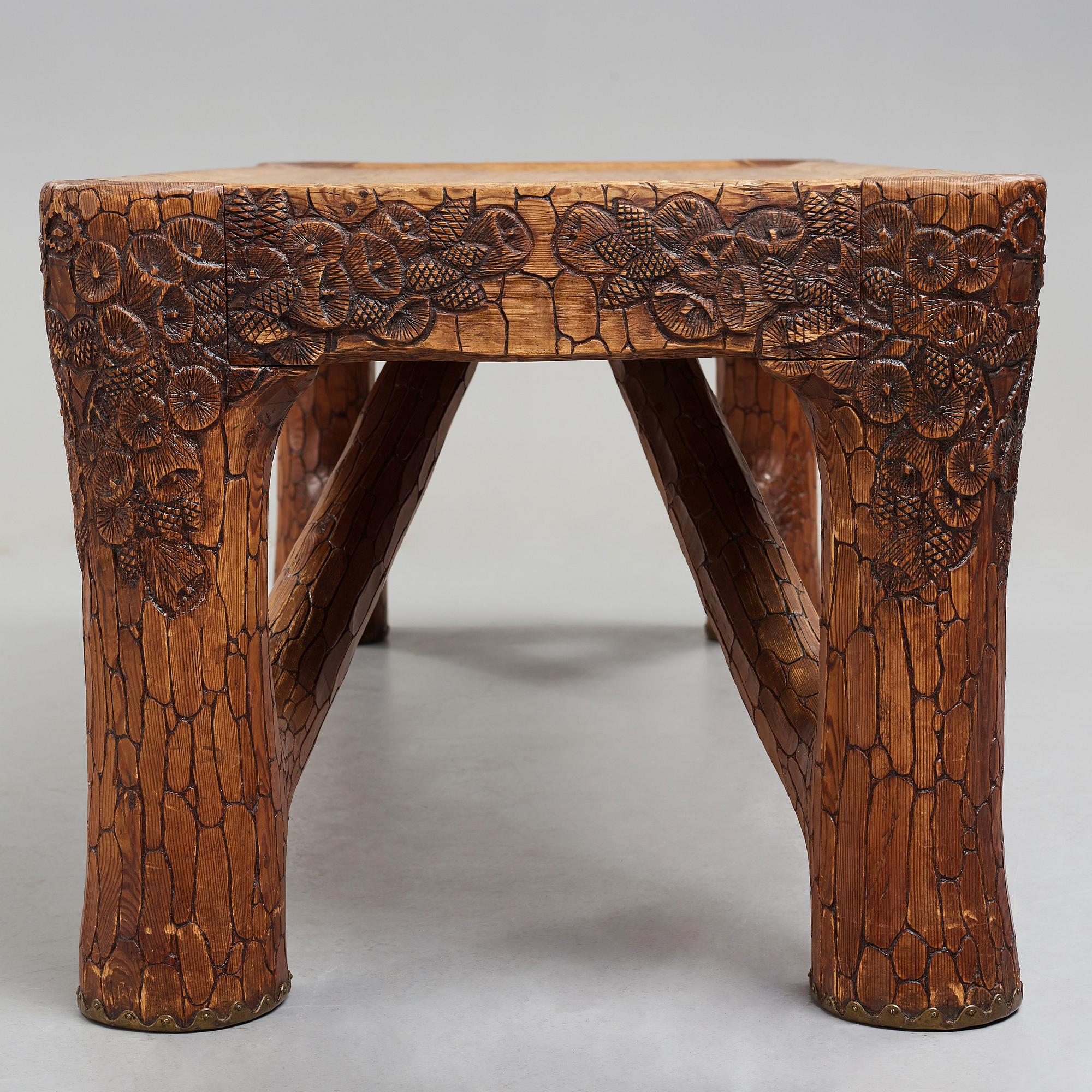 Gustaf Fjaestad, an Art Nouveau carved pine table, Arvika Sweden 1914, a double to the table in the Thiel Collection,