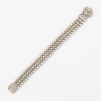 An 18K white gold bracelet set with cultured pearls and round brilliant-cut diamonds.