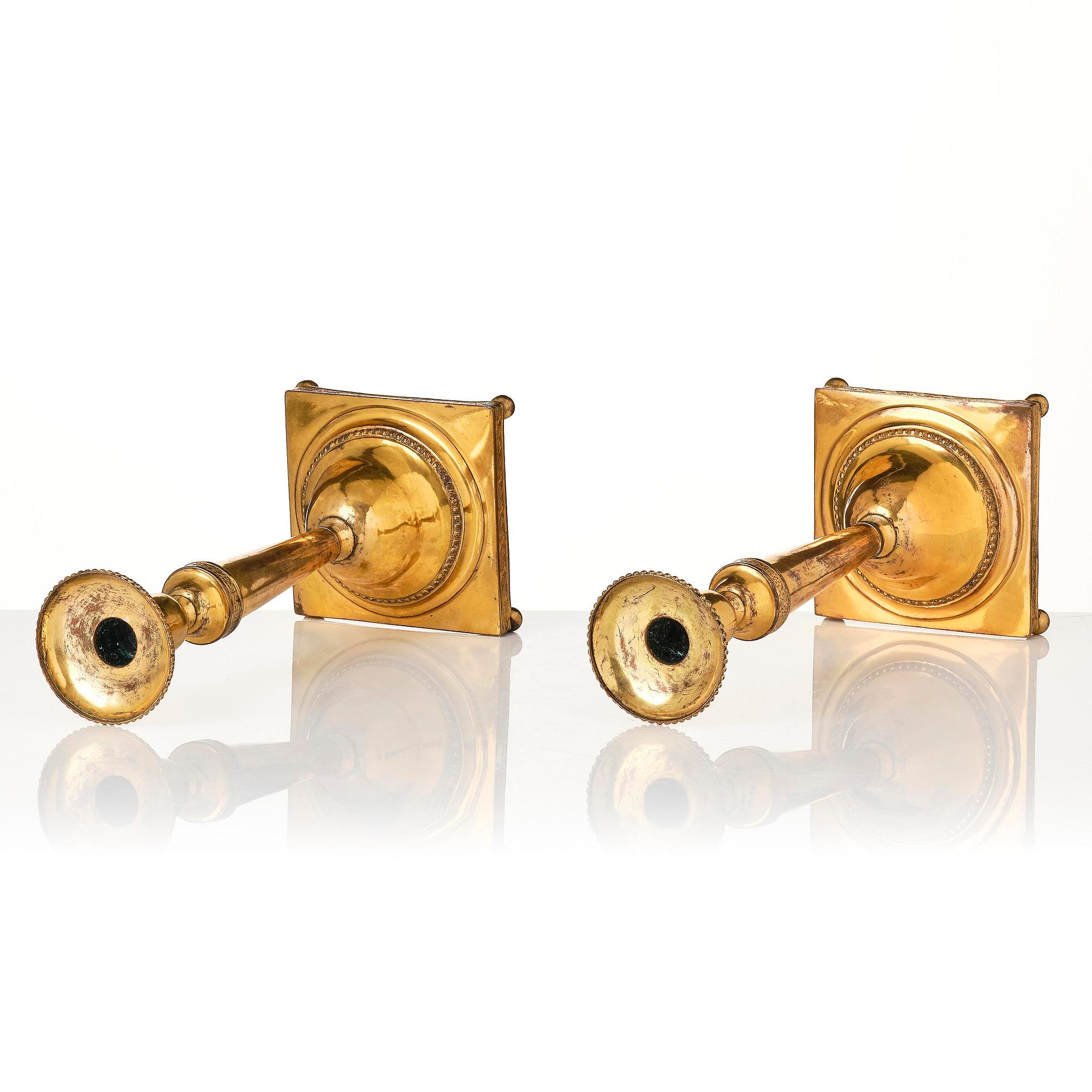 A pair of late George III gilt-copper candlesticks, early 19th century.