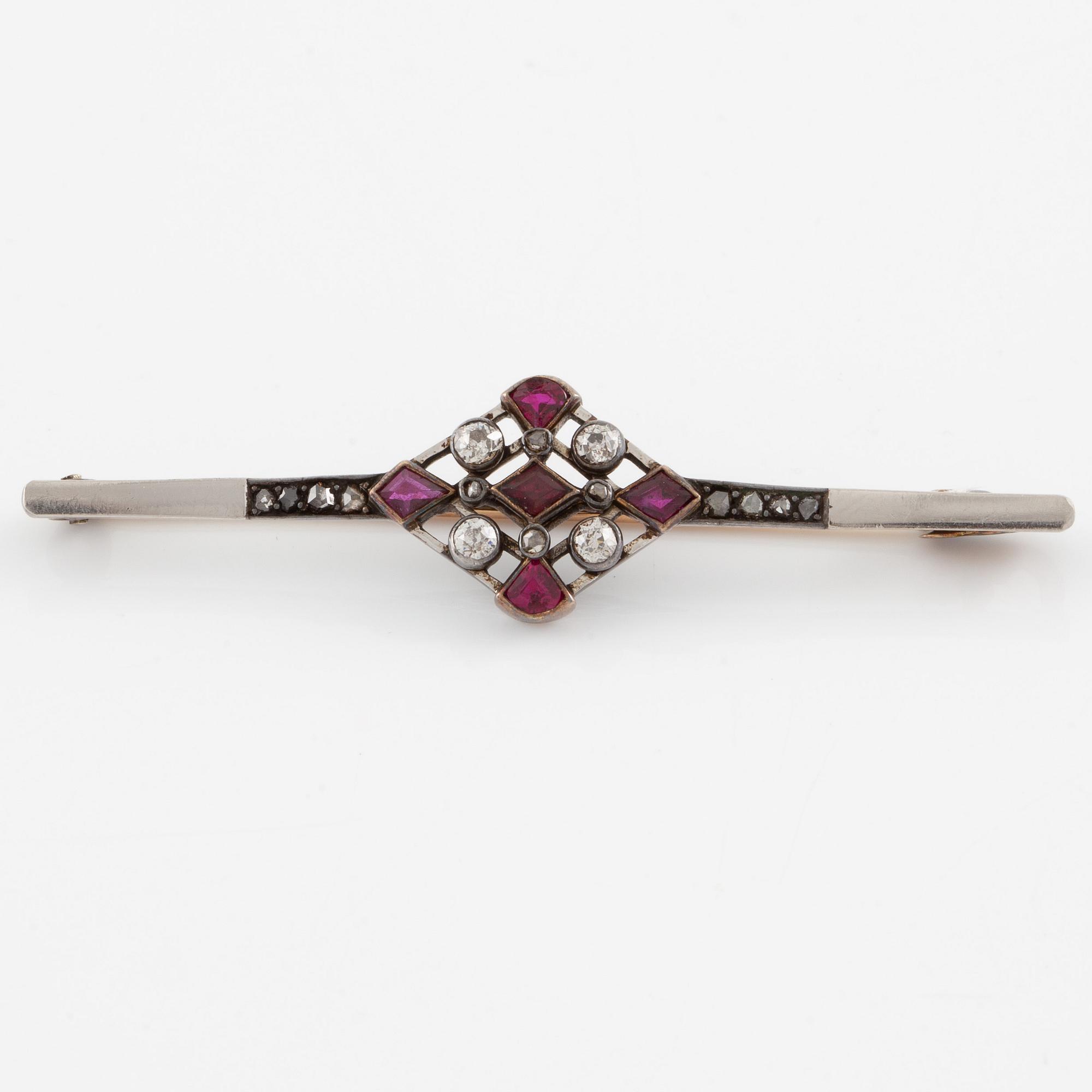Brooch platinum and 14K gold set with old- and rose-cut diamonds and red stones.