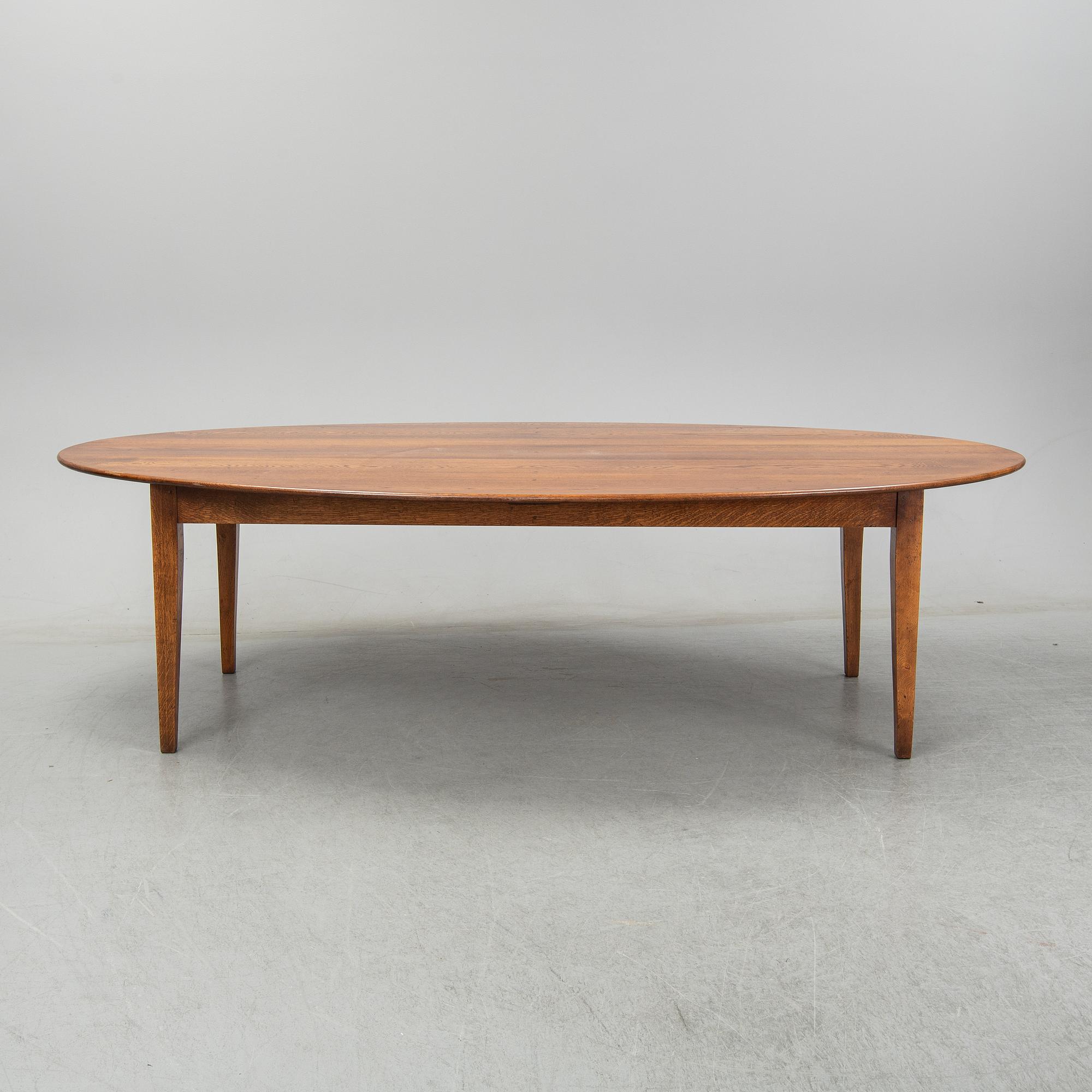 An stained oak dining table with eight chairs.