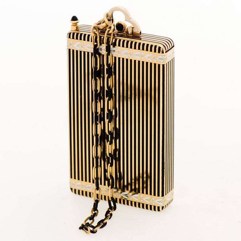 A Cartier Art Deco Vanity Case/Minaudière in 18K gold, black enamel and onyx. on the inside a mirror, a separate compartment with lid, a...