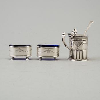 A silver mustard can and a pair of salt cellars. british. Dated 1879 resp. 1911.