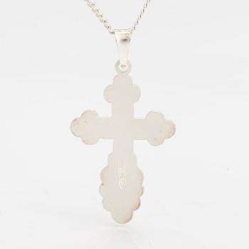 A stelring silver necklace with a cross.