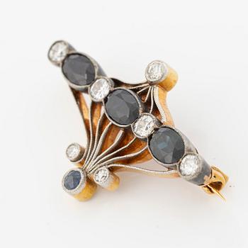 Brooch 18K gold and platinum set with step-cut sapphires and round brilliant-cut diamonds.
