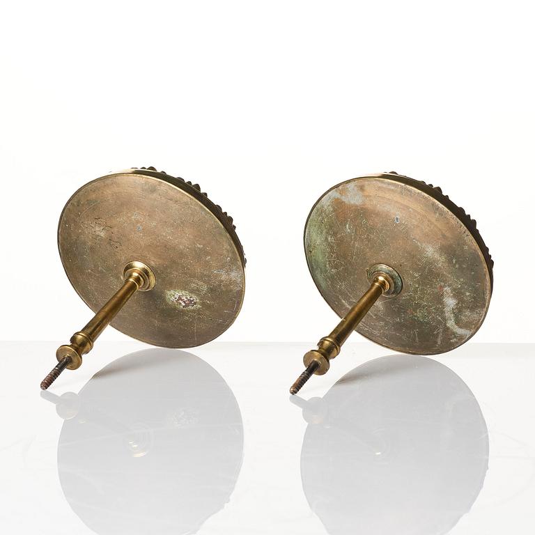 A pair of presumably English Empire repoussé gilt-brass and painted glass curtain tiebacks, early 19th century.