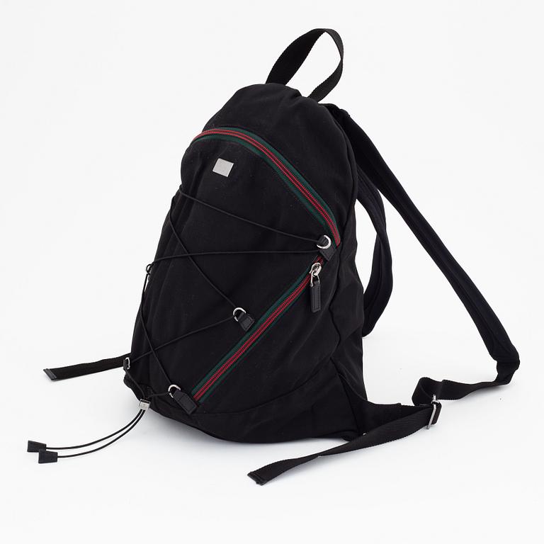 Gucci, a black canvas backpack.