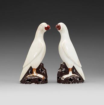 A pair of white andred glazed figures of parrots, late Qing dynasty.