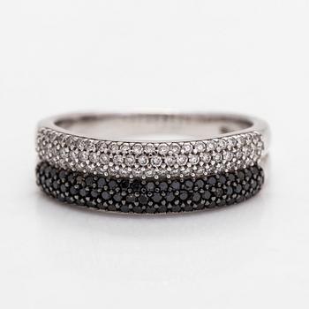 An 18K white gold ring with black and white diamonds.