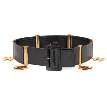 507. CHANEL, a black leather belt with golden logo charms.