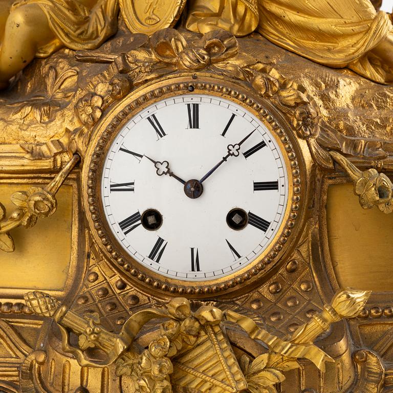 A table clock and a pair of candelabras, Louis XVI-style, France, beginning of the 20th century.