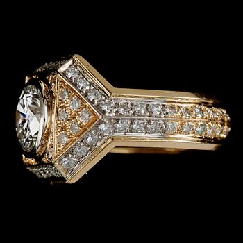 RING, 18k guld med briljantslipad diamant ca 2.95 ct, omgärdad av mindre briljantslipade diamanter totalt ca 1.50 ct.