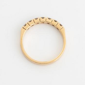 An 18K gold ring set with round briliiant-cut diamonds.